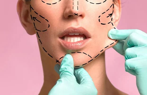 Cosmetic surgeon marking facelift treatment lines on woman’s face before plastic surgery procedure